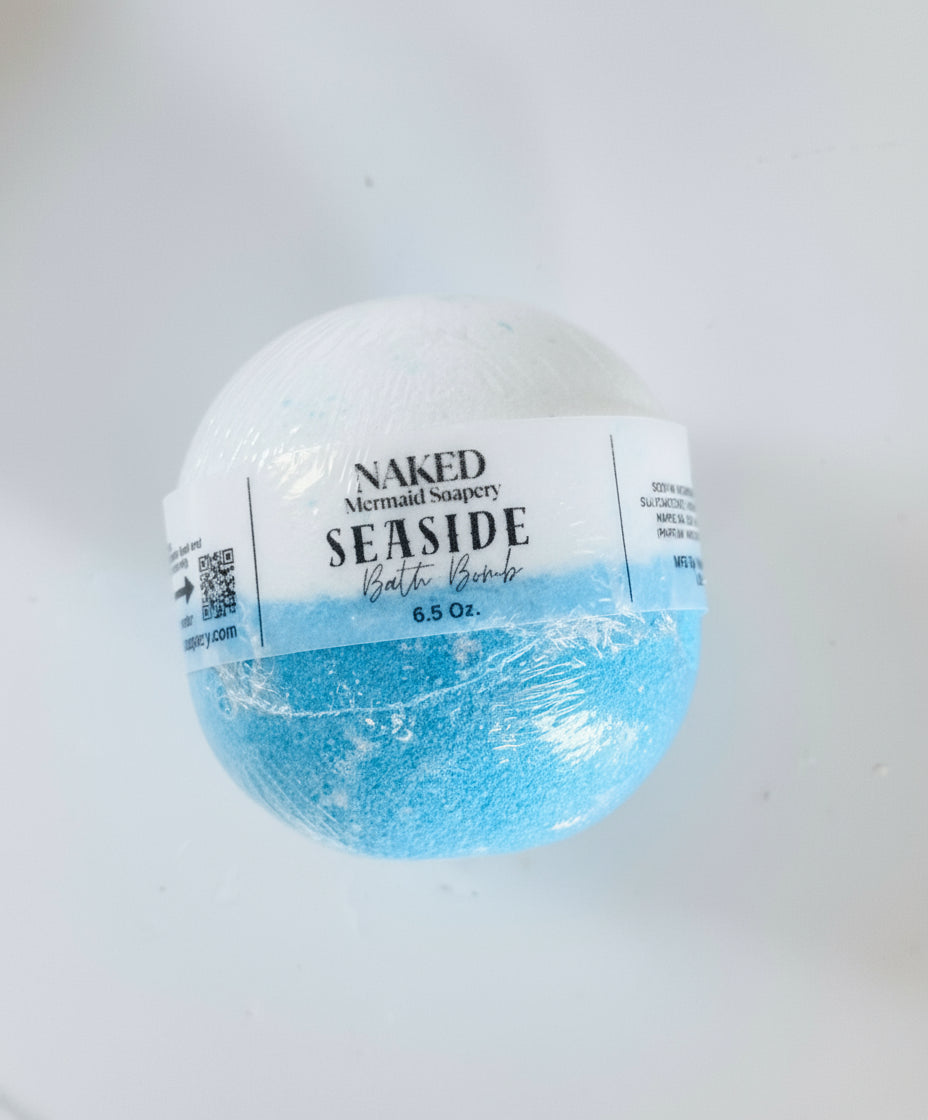 Bath bomb labeled 'Naked Mermaid Soaps' with a white and blue design on a light gray background