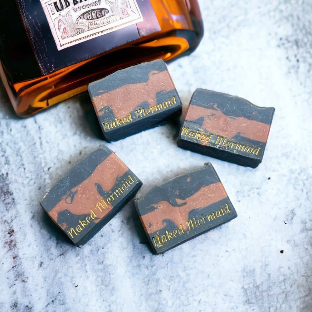 Handcrafted natural soap bars with 'Naked Mermaid' branding, artisan skincare on textured surface