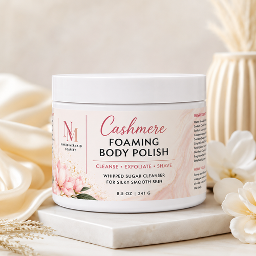 Cashmere Foaming Body Polish by Naked Mermaid Soapery in an 8.5 oz white jar with a luxurious cream and gold label. This whipped sugar body polish gently cleanses, exfoliates, and creates a rich lather for shaving while leaving skin silky smooth and delicately scented with the warm, comforting Cashmere fragrance.