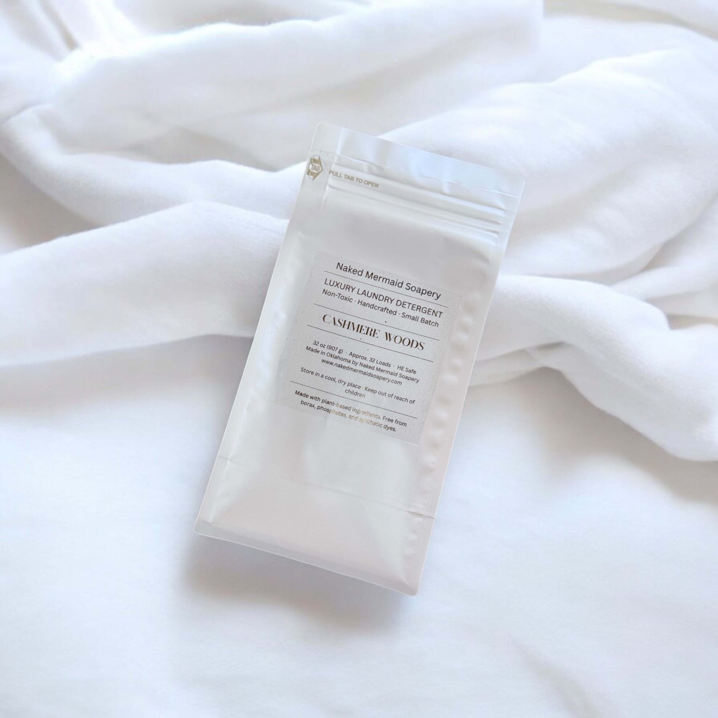 Cashmere woods laundry detergent in a white 32 oz bag