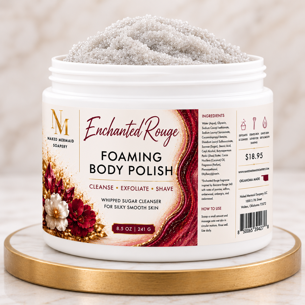 Enchanted Rouge Foaming Body Polish by Naked Mermaid Soapery in an 8.5 oz white jar with a luxurious cream and burgundy label. This whipped sugar body polish gently cleanses, exfoliates, and creates a rich lather for shaving while leaving skin silky smooth and beautifully fragranced with an elegant blend  featuring warm amber, jasmine, saffron, and woody notes.