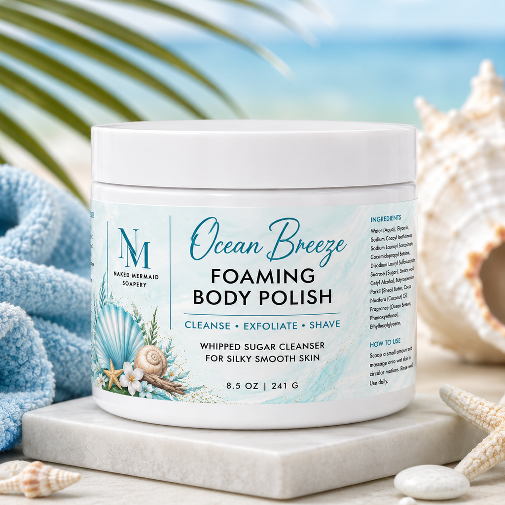 Ocean Breeze Foaming Body Polish by Naked Mermaid Soapery in an 8.5 oz white jar with a fresh coastal blue label. This whipped sugar body polish gently cleanses, exfoliates, and creates a rich lather for shaving while leaving skin silky smooth and lightly fragranced with refreshing sea salt, jasmine, and driftwood notes.