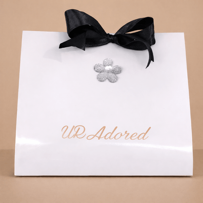 Luxury skincare gift set "UR Adored" with Cheriso 76 fragrance, featuring elegant packaging with floral decoration and black ribbon.