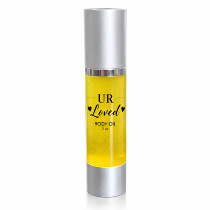 UR Loved 2 oz body oil in a clear airless pump bottle with silver cap and base, featuring a clear label with black text and filled with golden jojoba, amla, rosehip, and vitamin E oils on a clean white background.